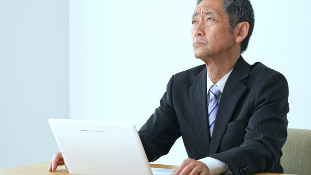 想想拿着笔记本电脑的中年商人。图片下载