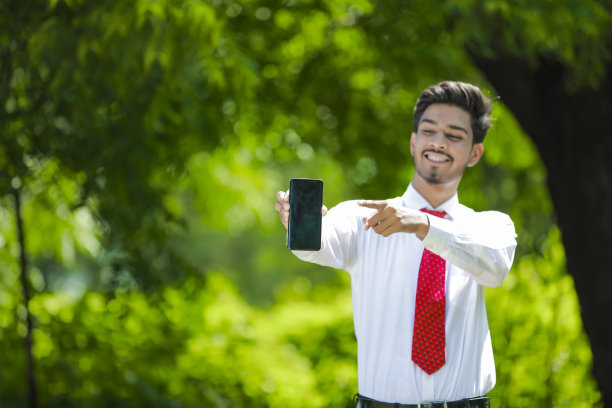 拷贝他智能手机上的空间。自信的印度年轻人展示他的智能手机图片下载
