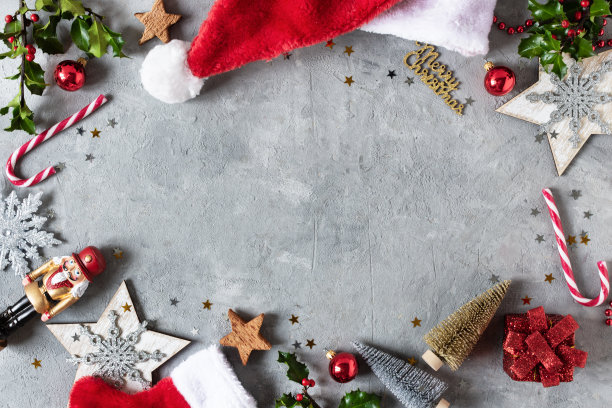 圣诞背景与圣诞装饰，圣诞糖果手杖，冬青浆果树枝顶视图上的灰色背景。图片下载