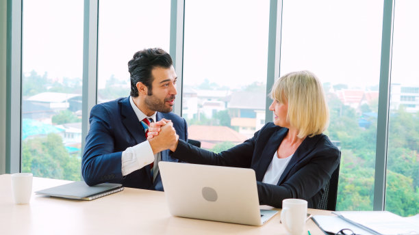 两个快乐的商业人士在办公室庆祝图片下载