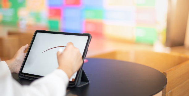 女性的手使用数字平板与铅笔触屏在办公桌办公桌上作画，为共同工作空间的新常态概念。图片下载