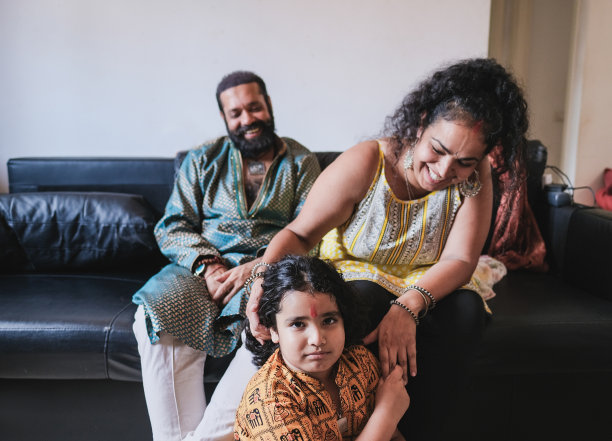 快乐的印度家庭享受时间在一起在家里，而穿着传统的服装-集中在孩子图片下载