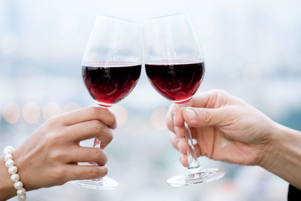 手握红酒庆祝宴会成功。年轻人在派对上举杯，工作后喝酒，努力放松和享受。庆祝概念，干杯!图片下载