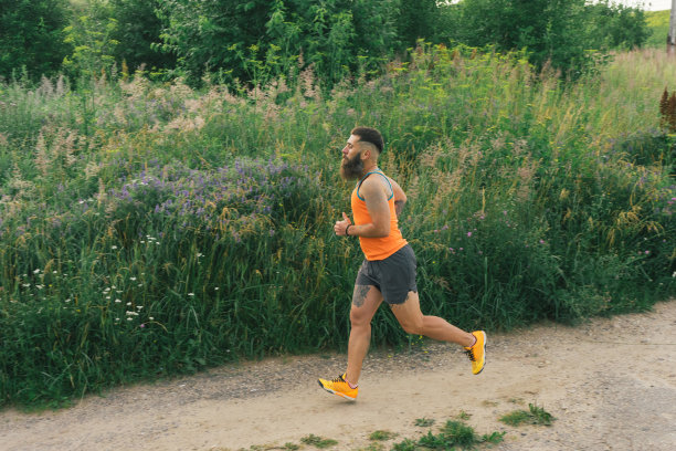 为健身和健康的生活方式进行户外日出训练的大胡子马拉松运动员图片下载