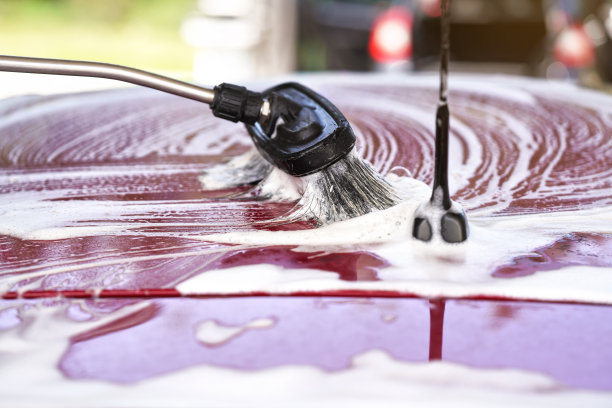 用白色洗发水和泡沫在自助洗车房冲洗的红色车顶上刷几下图片下载