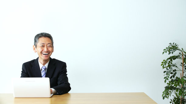 办公室里微笑的中年商人。图片下载