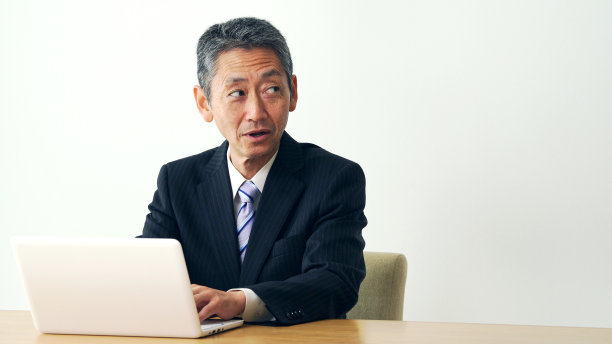 办公室里微笑的中年商人。图片下载