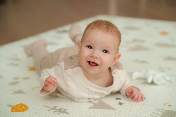 快乐的宝宝躺在游戏垫上图片下载