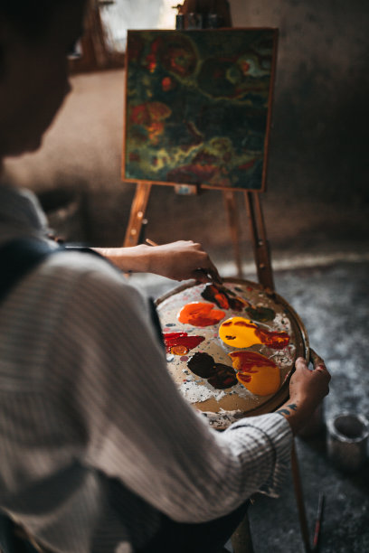 年轻女子在窗户附近画画图片下载