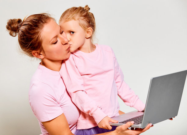 使用笔记本电脑的女孩和母亲特写图片下载