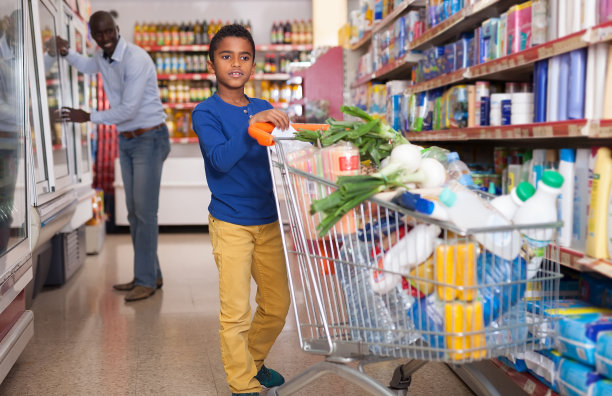 小孩推着购物车在商店里图片下载