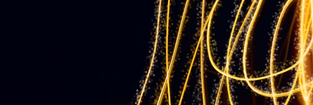 黑色背景上的节日金色灯光线条。图片下载