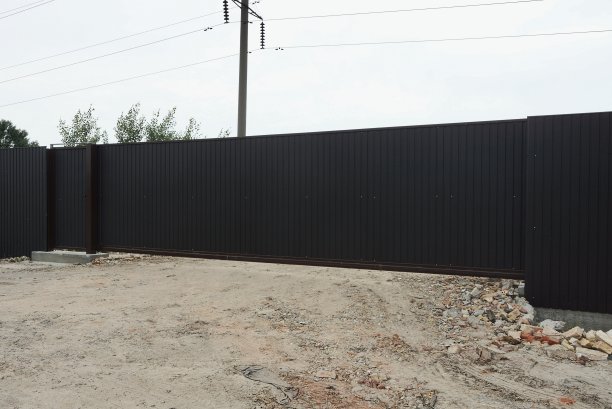 一扇长长的黑色金属门和栅栏的一部分图片下载