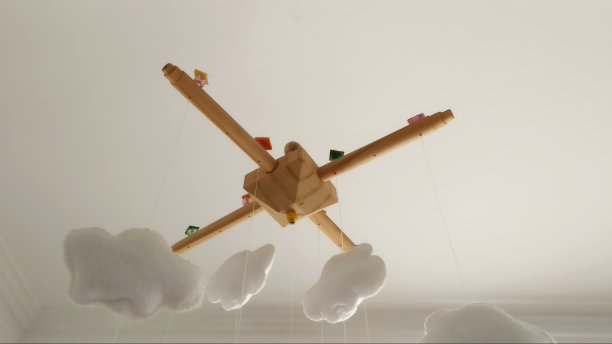 婴儿房移动吊在天花板上，木制底座上有五颜六色的气球和云朵。图片下载