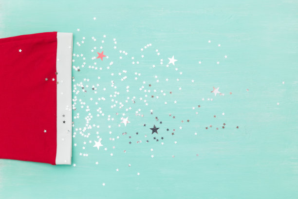 顶视图上的圣诞老人的帽子在旧木绿松石桌子或背景与闪闪发光的星星。圣诞节，新年，冬季和假期概念。图片下载
