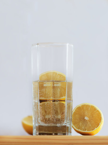 木桌上放着一杯水和切好的柠檬。图片下载