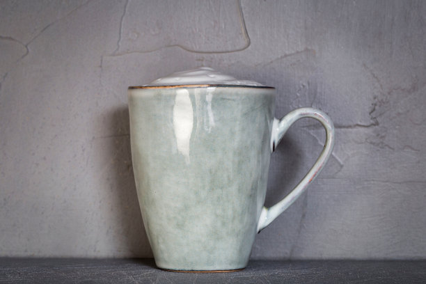 陶瓷杯白色泡沫灰色天然石材设计与混凝土墙背景，咖啡或茶的概念，复制空间图片下载