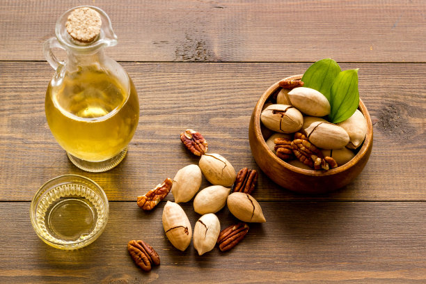 桌子上有一瓶山核桃油和坚果，靠近点图片下载