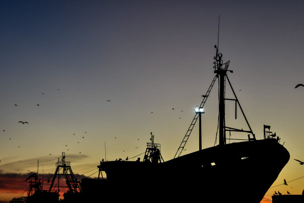 日落时船的剪影，照片为背景图片下载