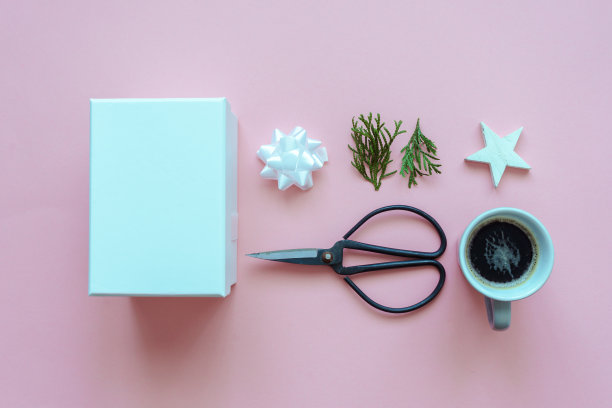 一个白色的礼品盒，一杯咖啡和包装材料在粉红色的背景图片下载