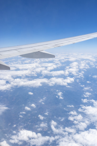 透过飞机窗口观看蓝天、白云和飞机机翼图片下载