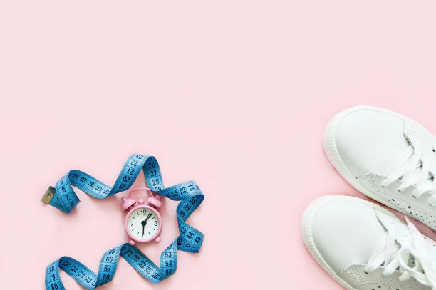白人女性的运动鞋，手表和卷尺。健康的概念。副本的空间。前视图。图片下载