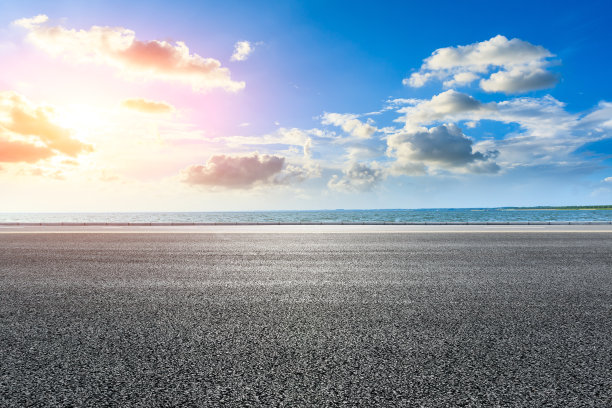日落时的柏油路和湖景。图片下载