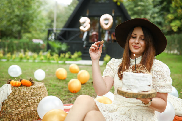 吃气球、生日蛋糕和马卡龙的女人，庆祝万圣节的快乐女人图片下载