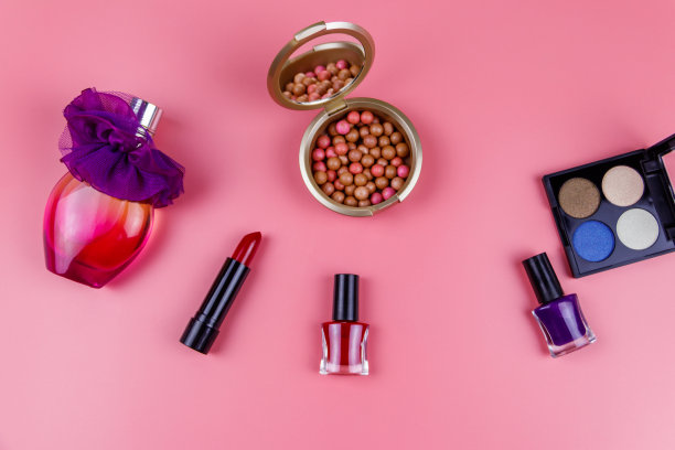 一套装饰化妆品在粉红色的背景。俯视图，平放图片下载