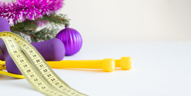 带绳子的厘米丝带，白色背景上有圣诞装饰的哑铃。图片下载