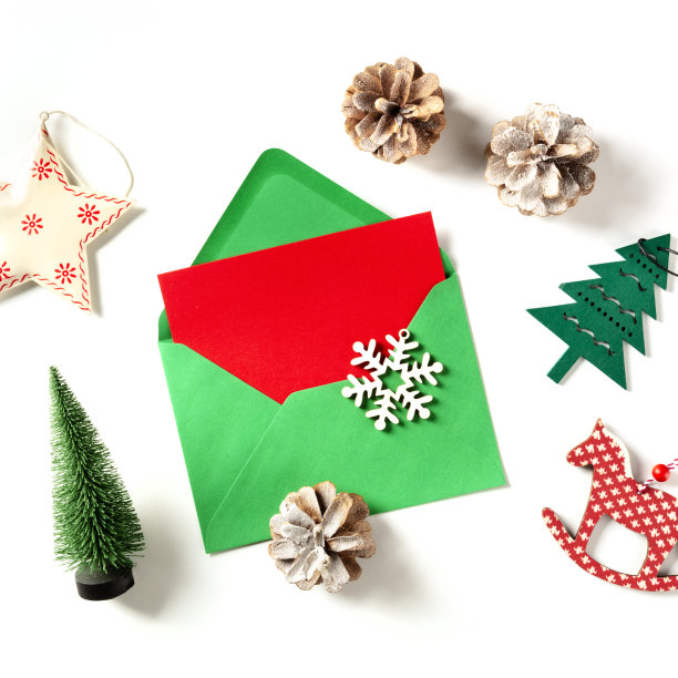一张绿色信封里的红色圣诞贺卡，在白色背景上拍摄的方形新年装饰图片下载