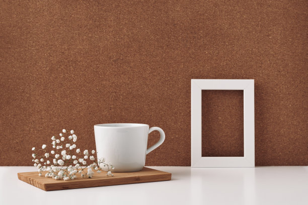框架，白花，杯，软木背景。模拟，复制空间。民间。图片下载