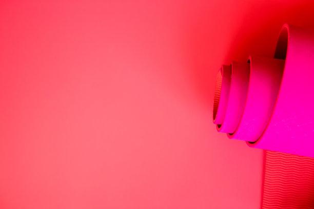 珊瑚色背景上的亮粉色深蓝色瑜伽垫图片下载