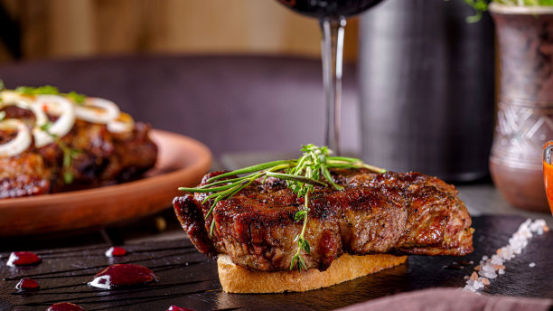 美国菜。烤猪肉排，躺在一片白面包上。在餐馆里用黑色的石板上菜。图片下载