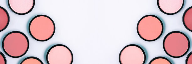 粉色腮红和粉饼粉在柔和的蓝色背景。横幅。放置文字，设计。前视图。热门的颜色。化妆。美容产品。色调的基础。平坦的躺,布局。美丽的概念。图片下载