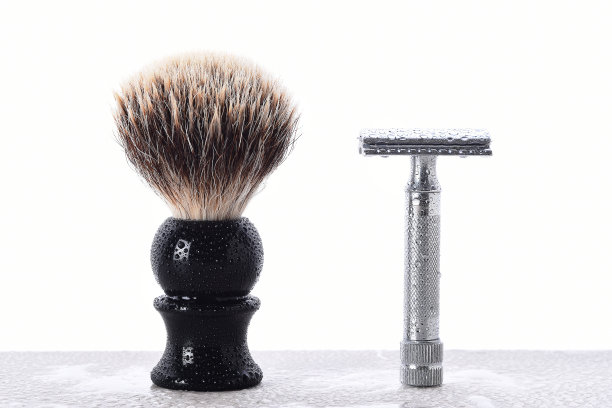 潮湿的浴室台面上放着一把男士剃须刀和刮胡刷图片下载