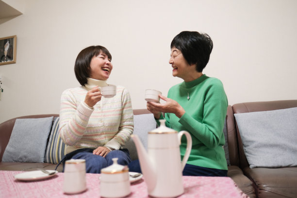 老年妇女和中年妇女一边喝茶一边聊天图片下载