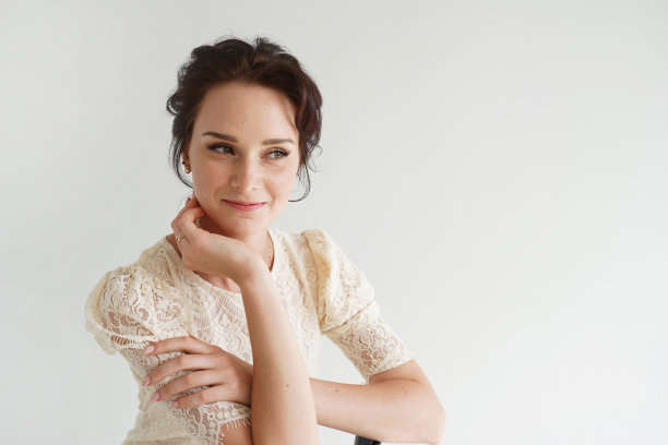 一个美丽的女人在白色的背景上穿着白色的裙子的特写肖像。图片下载