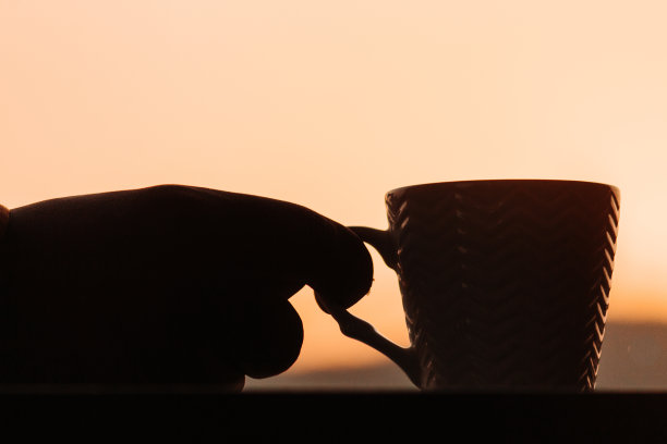 早晨在太阳前握着咖啡杯的剪影图片下载