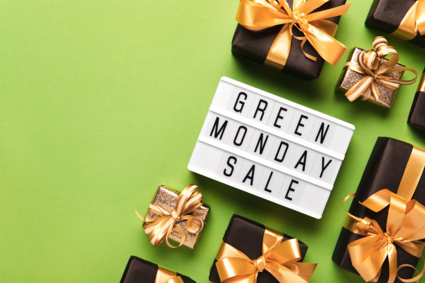 灯箱与绿色星期一销售文字和滚黑色礼盒在绿色纸的背景，拷贝空间图片下载