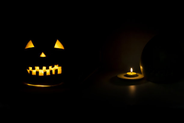 万圣节的象征，可怕的脸后面的蜡烛与火图片下载