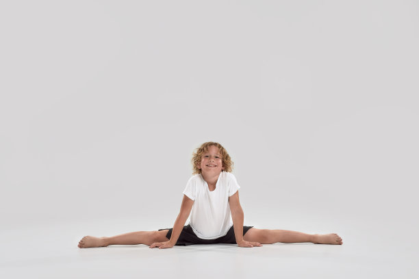 全长镜头的小男孩微笑在相机，做分裂孤立在灰色背景图片下载