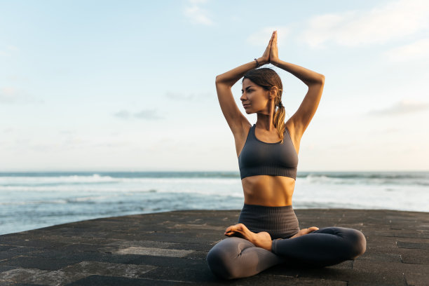 年轻女子在大自然中做瑜伽体式，海景。图片下载