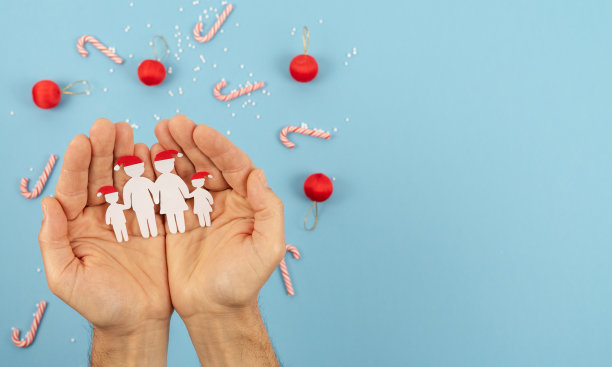 用剪纸剪成的手，牵着一家人过圣诞节。团结的家庭庆祝圣诞节。图片下载