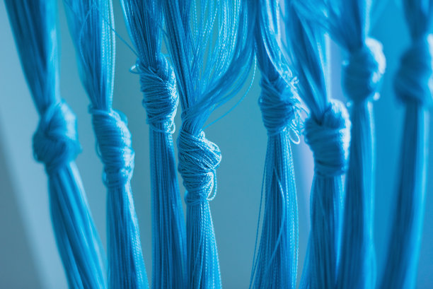 绿松石色背景上的蓝色绳结。图片下载