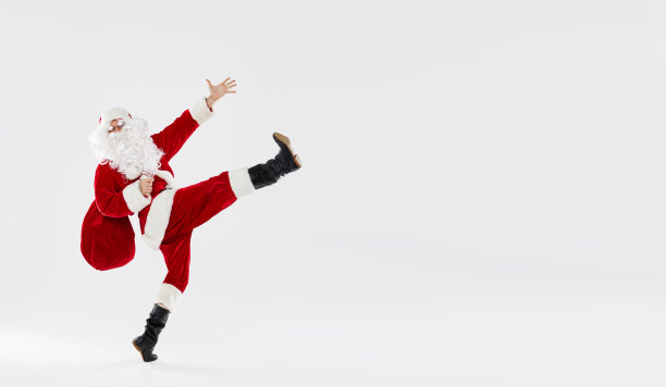 在白色的背景上，快乐的圣诞老人带着礼物跳起舞来。概念为圣诞节和新年假期和销售。横幅图片下载