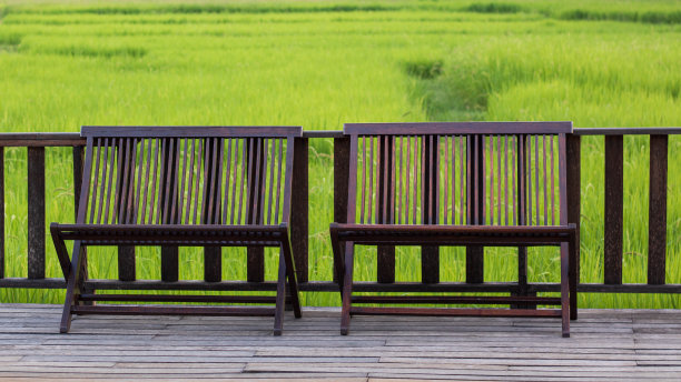 木制长椅或椅子放松在木阳台上与稻田的景色。图片下载