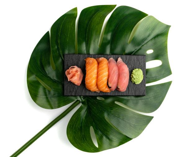 三文鱼握寿司和金枪鱼寿司放在绿色的棕榈叶上图片下载