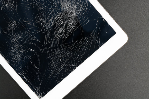 现代平板电脑与高度破碎的屏幕上的黑色背景。图片下载
