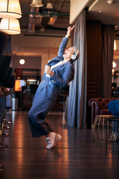 美丽的女人喝着咖啡，听着音乐，跳着舞图片下载